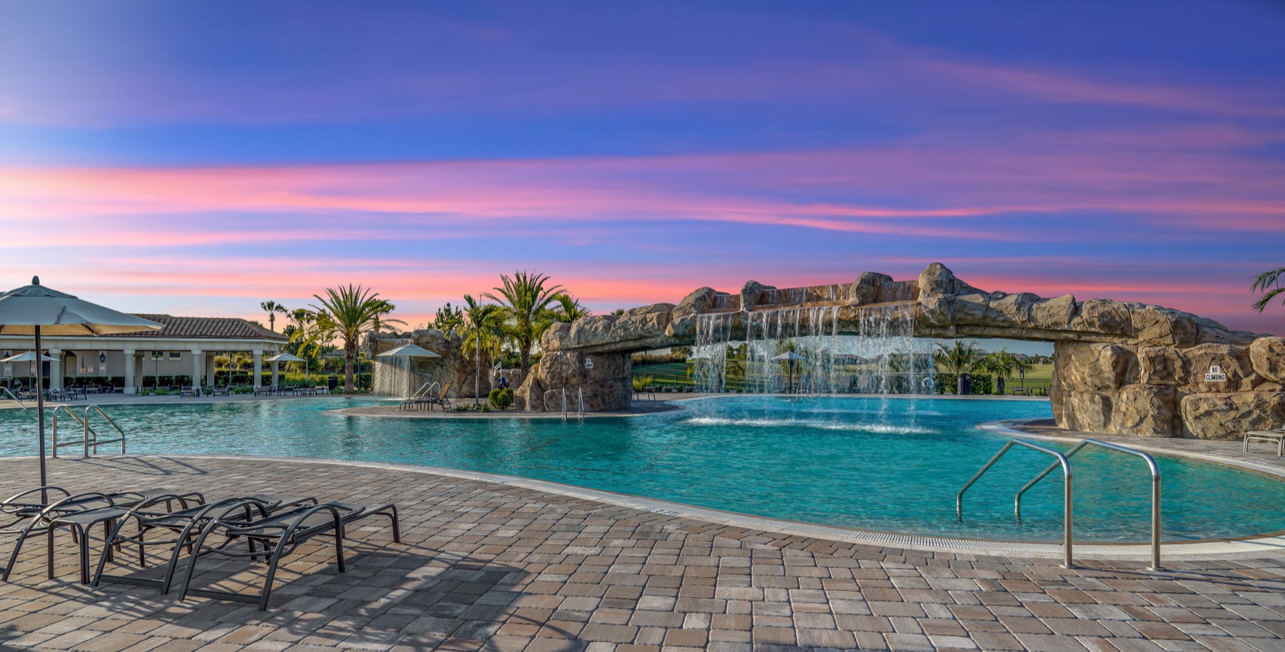 The lagoon pool at sunset with cascading waterfalls